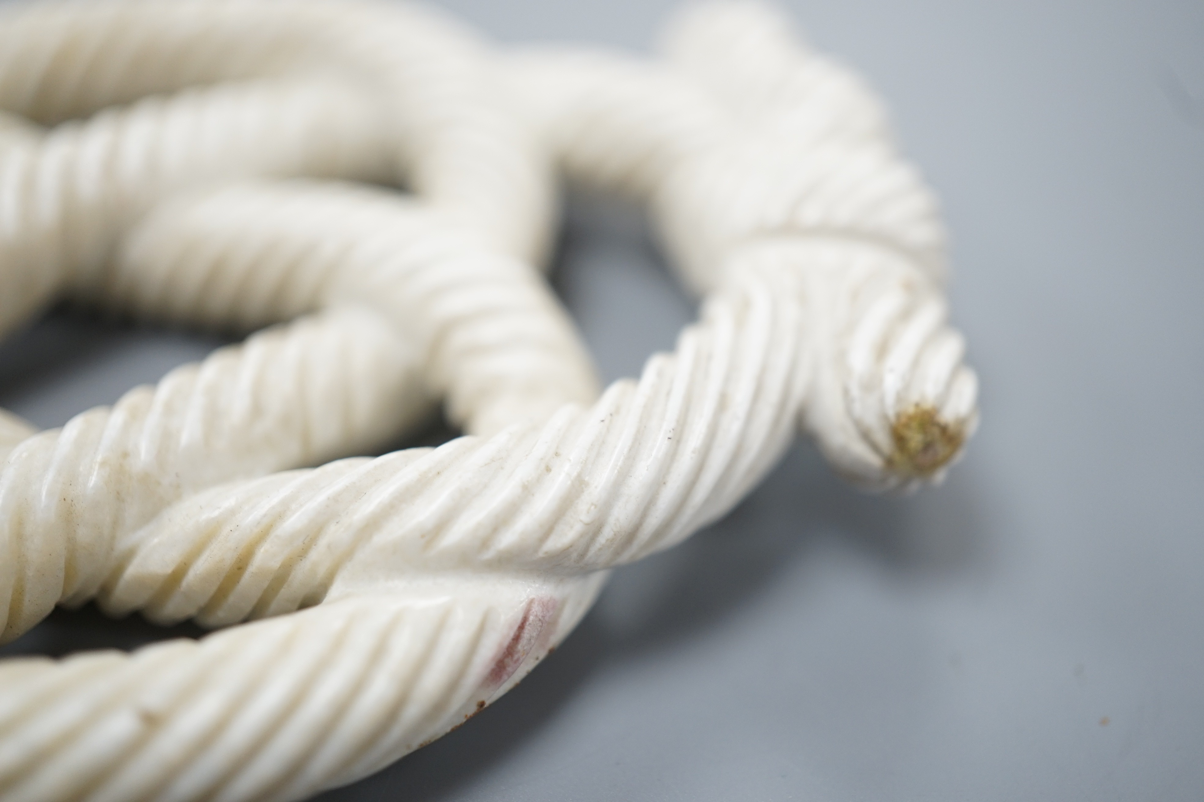 A Chinese hardstone eternal knot carving, 19th century, possibly burnt jade, 8.4cm